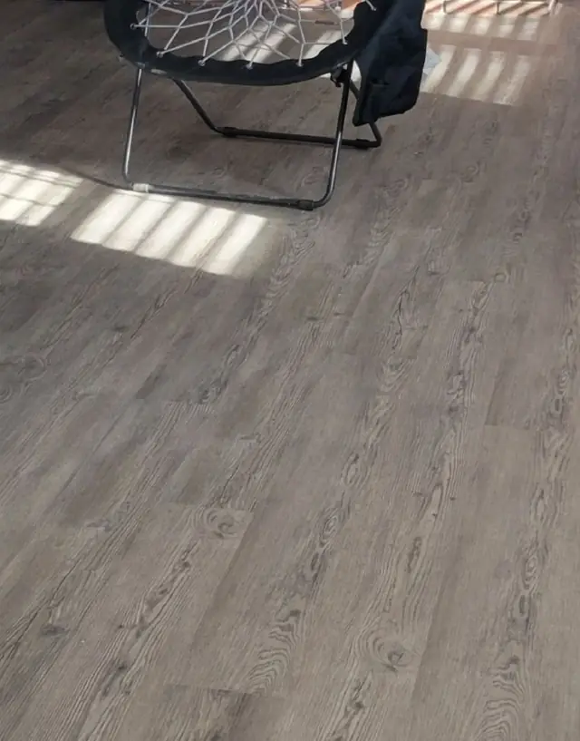 New grey wood-look plank flooring laid across a sunlit room